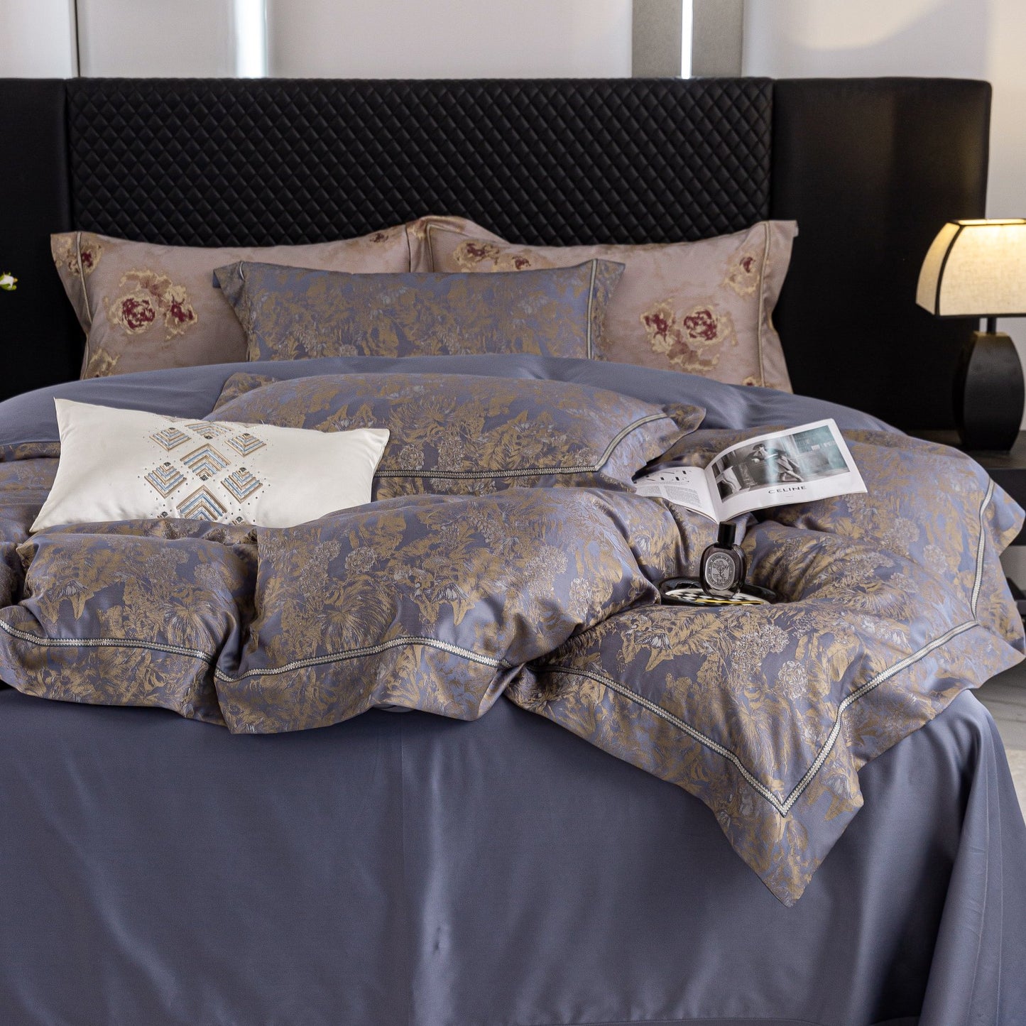 Luxurious Versailles sateen bedding set in elegant blue and gold tones with floral embroidered pillows on bed.
