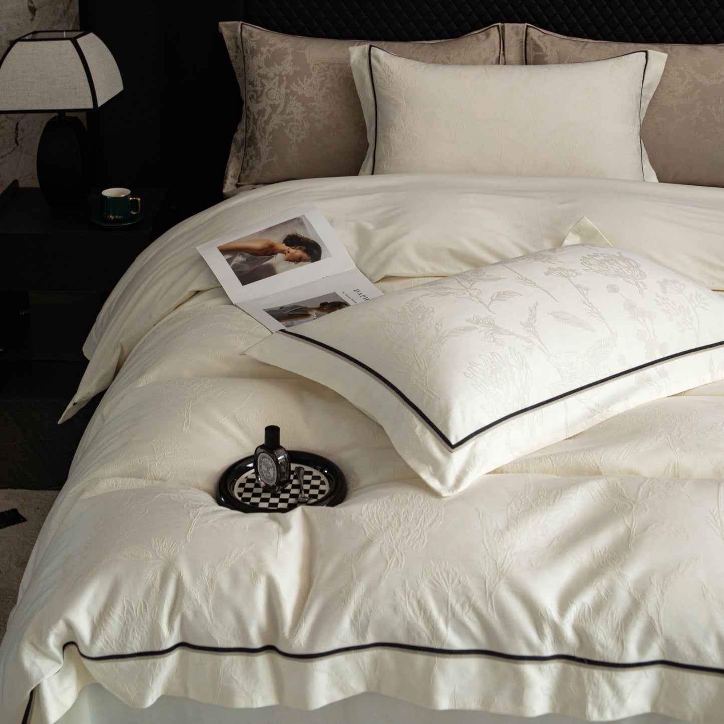 Luxurious Paris sateen bedding set in soft cream with black piping, made from smooth breathable Tencel cotton, arranged on bed.