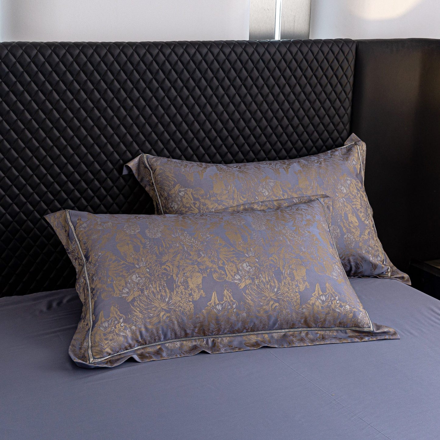 Luxurious Versailles sateen bedding set with elegant gold floral pattern on smooth blue Tencel cotton pillowcases.