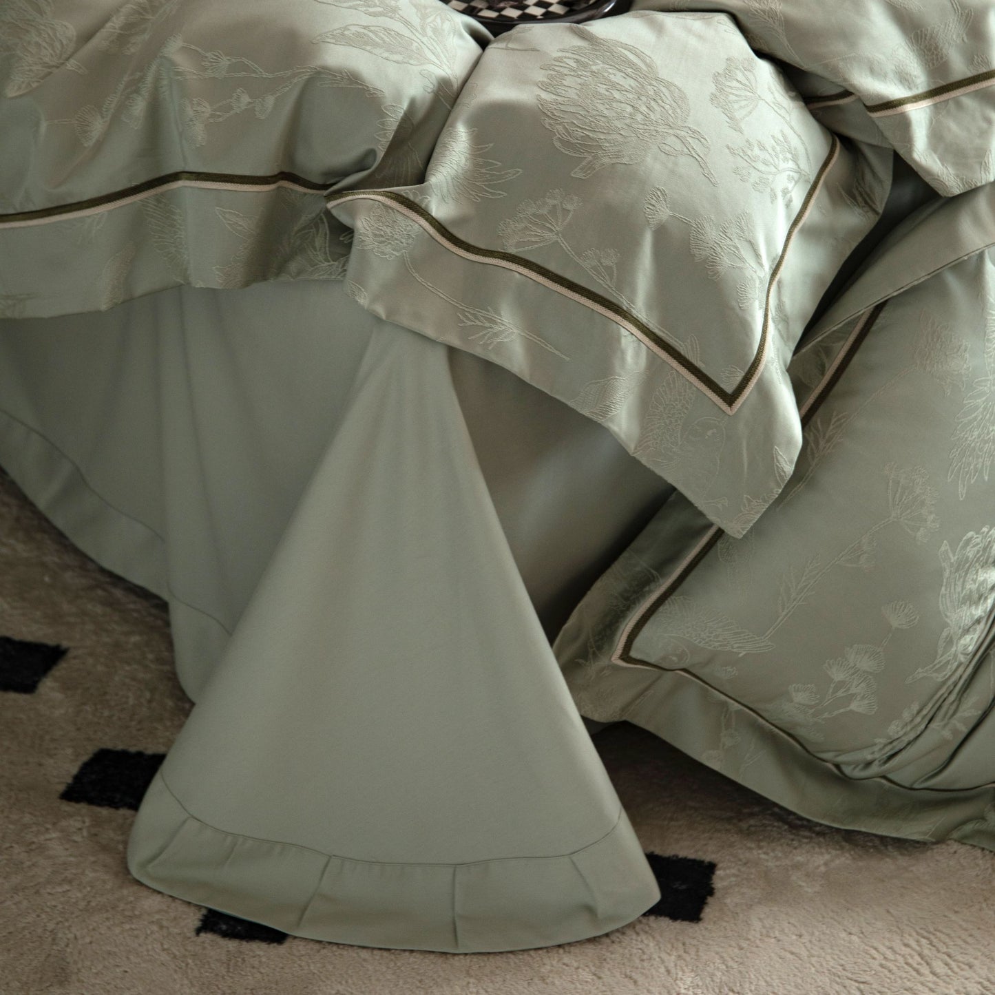 Luxurious Avignon sateen bedding set in soft muted tones with detailed embroidery on pillowcases and duvet cover.