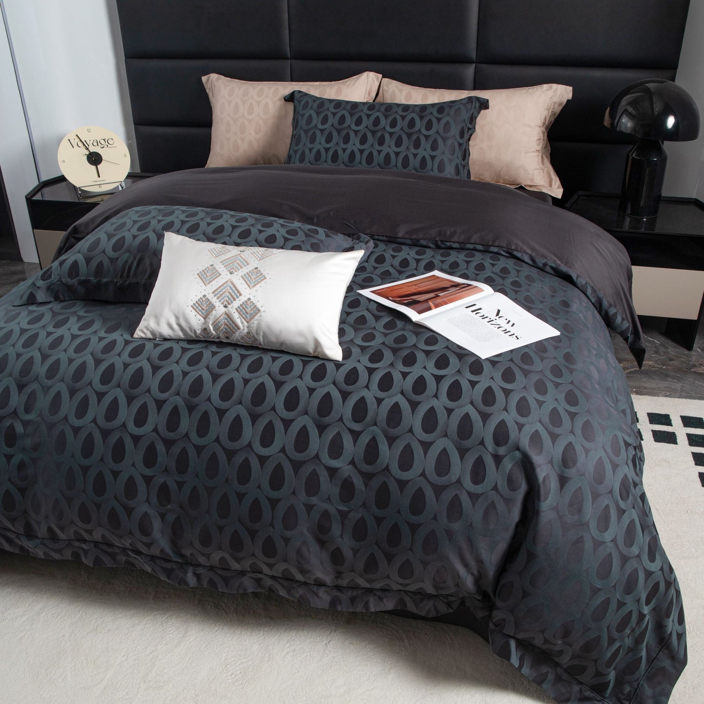 Modern geometric sateen bedding set in deep charcoal with soft beige and slate grey pillowcases on a styled bed.