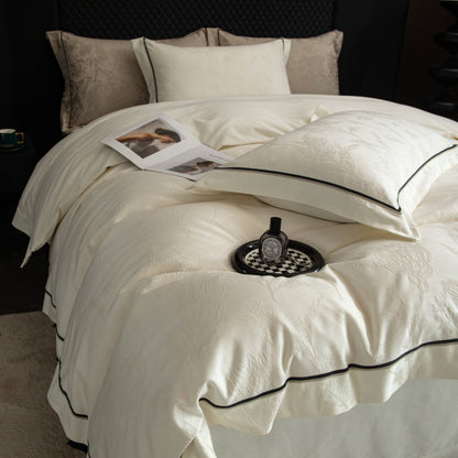 Luxurious cream sateen bedding set with subtle pattern and black trim on a neatly made bed in a cozy bedroom setting