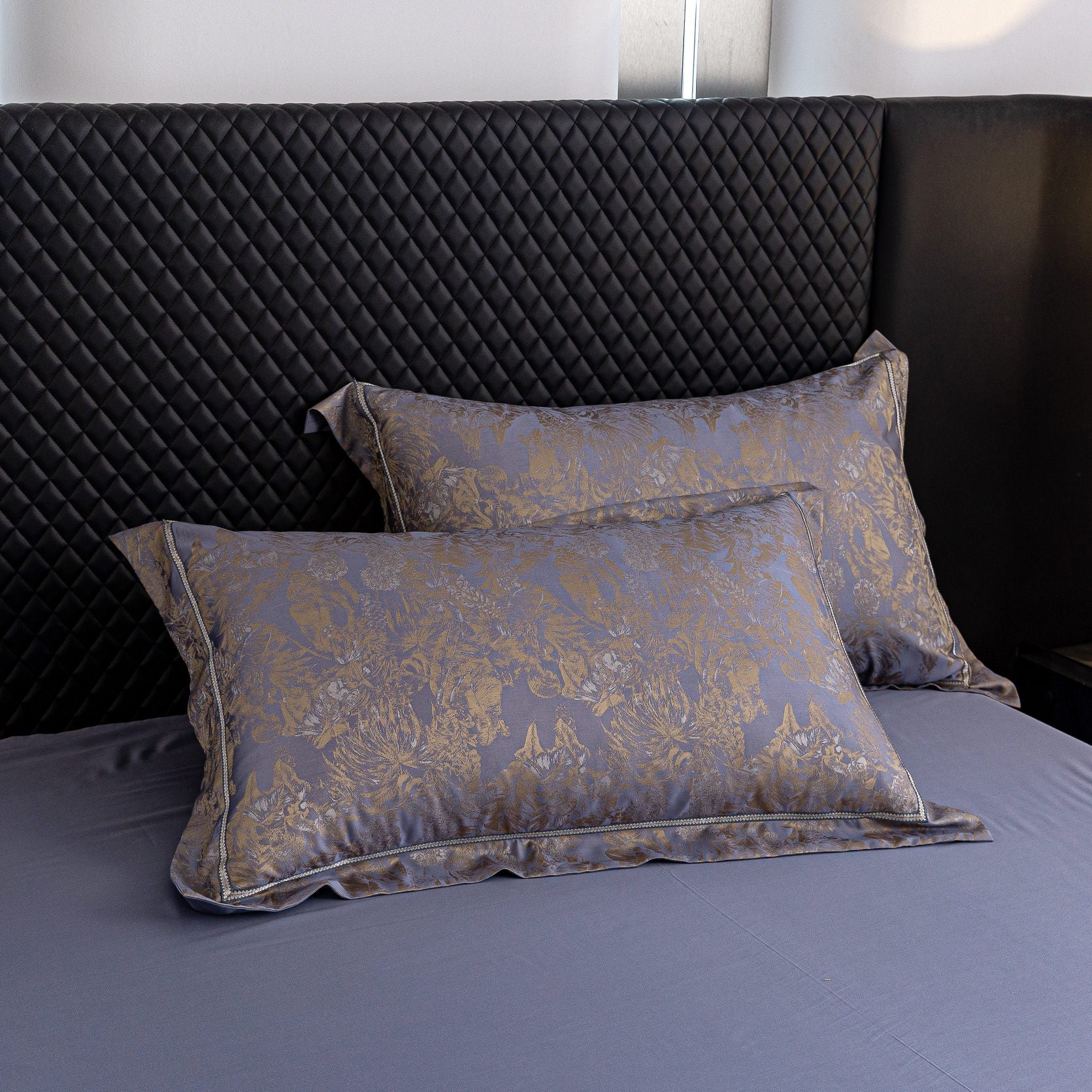 Luxurious Versailles sateen bedding set with elegant gold floral pattern on smooth blue Tencel cotton pillowcases.