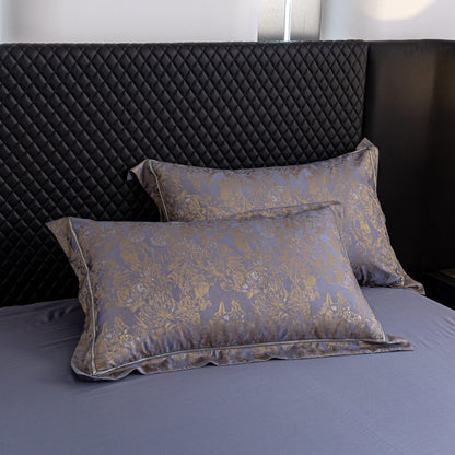 Luxurious Versailles sateen bedding set with elegant gold floral pattern on smooth blue Tencel cotton pillowcases.