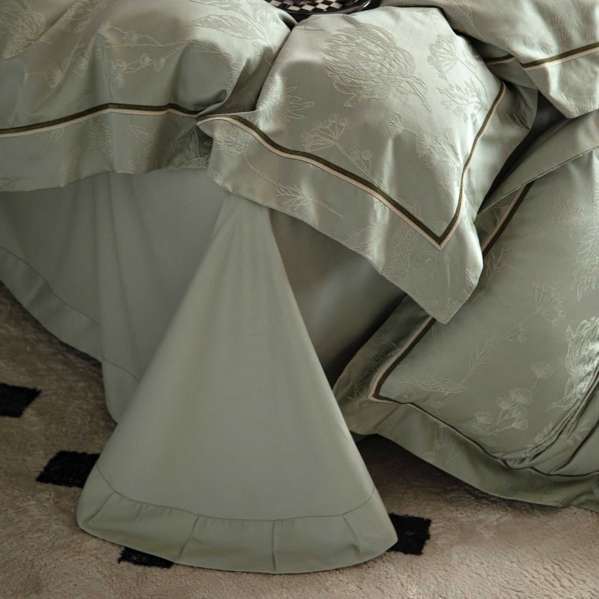 Luxurious Avignon sateen bedding set in soft muted tones with detailed embroidery on pillowcases and duvet cover.