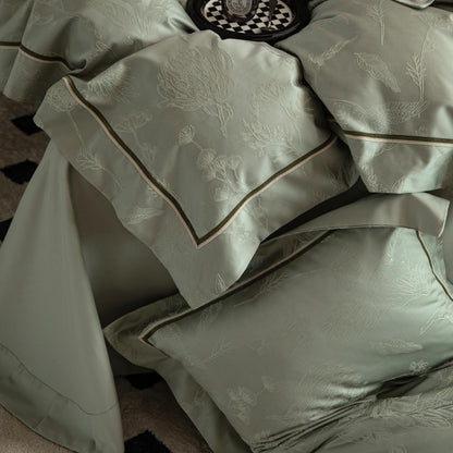 Luxurious Avignon sateen bedding set in soft green with botanical embroidery and smooth Tencel cotton fabric.