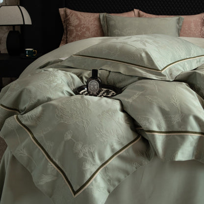 Luxurious Avignon sateen bedding set in soft green with floral embroidery and contrast piping on a modern bed.